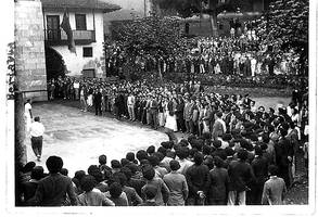 Hurragotik atarata, Berriatuko frontoi zaharrean, esku pilota partida ikusten hainbat herritar.