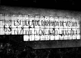 Asterrikako auzo-eskola zenaren idazkun zaharra, apurtuta: 63 Escuela de barriada de Vizcaya. Bizkaya'ren auzo-ikastola