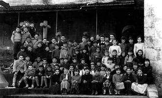 1957-1958 ikasturteko Berriatuko eskolako ikasleen taldeko argazkia, eleizako eskaileretan.